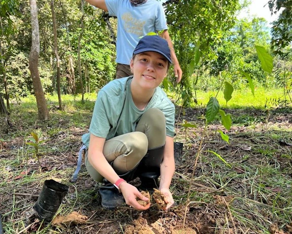 Millie planting a tree in reforesting areas of Borneo