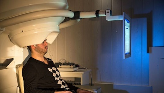 Man sitting in a MEG scanner