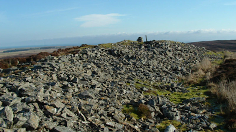 A view down the long mound of rocks and stones of the cairn. 
