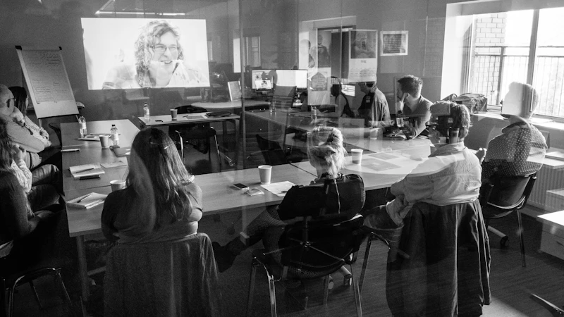 People around a conference table seen through a window