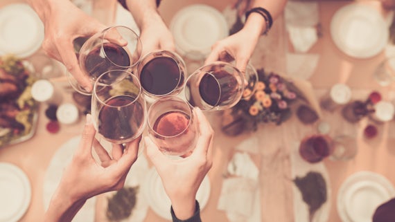 Image of people drinking wine with wine glasses toasting