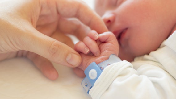 Image of a baby with the mother's hand holding its hand