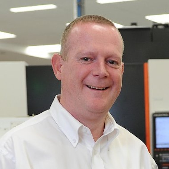 Image of a man wearing a white shirt and smiling into the camera