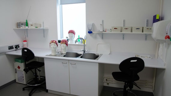 EEG preparation room with electrodes, skull caps, sinks, cupboards and chairs