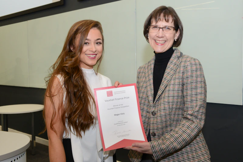 Two women pose with certificate