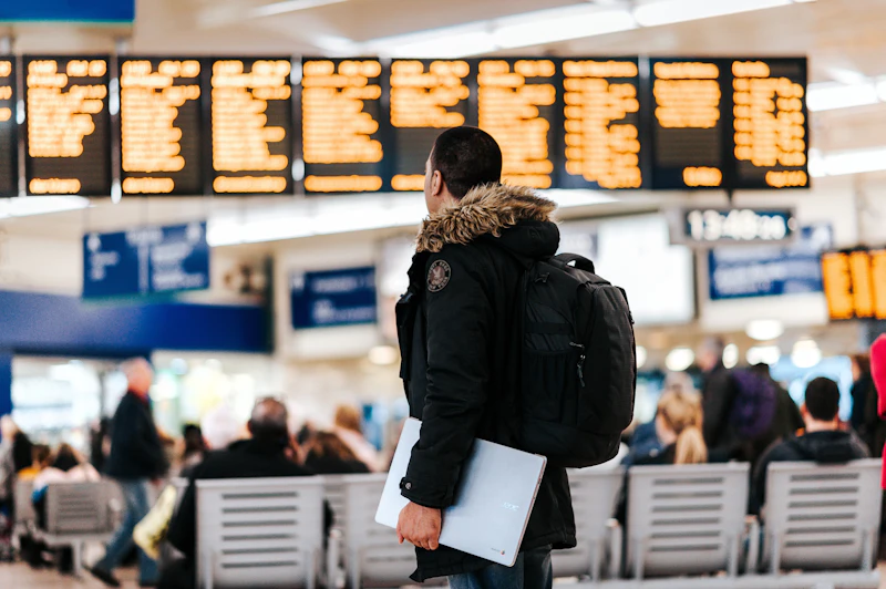 person in airport looking at departure board
