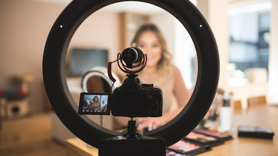 A young woman vlogging herself doing makeup.