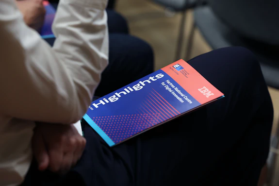 A Hartree National Centre for Digital Innovation brochure sits in someone's lap. 