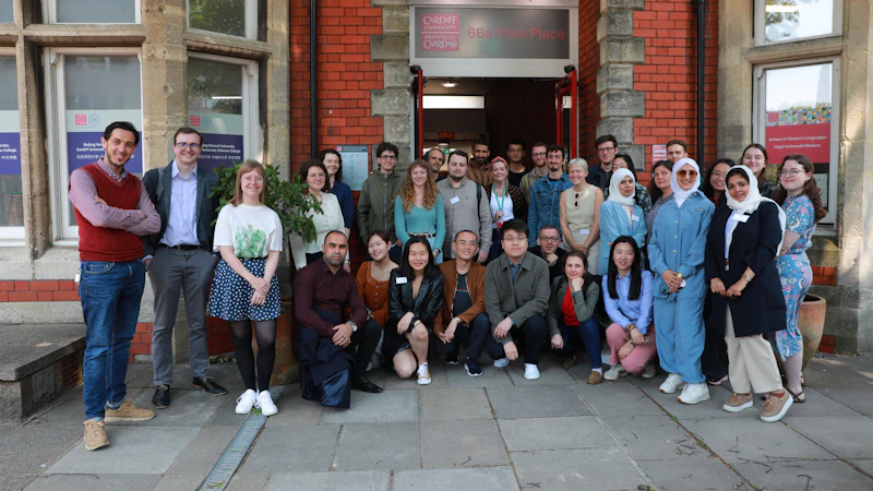 A group of people standing outside a building smiling at the camera.