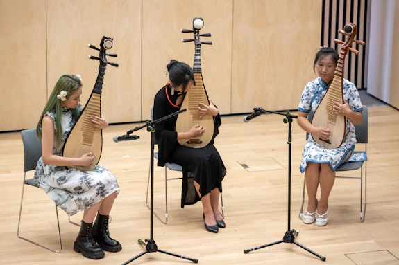 Three tutors performing on the Pipa