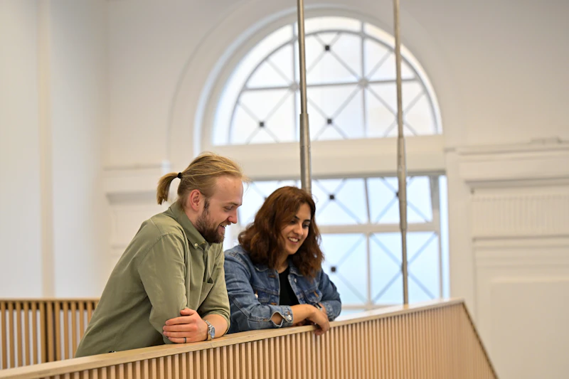 Students chatting on the landing of a university building