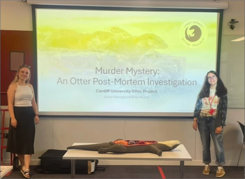 Holly Hulme and Chloe Hawthorn standing in front of a screen displaying a presentation titled 