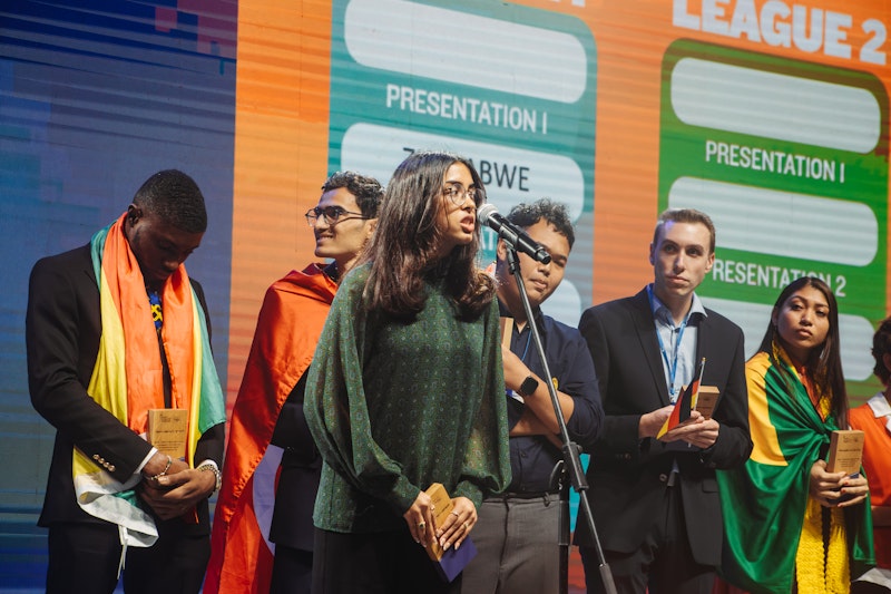 A female student is speaking on stage at a competition