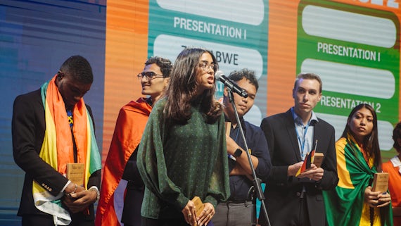 A female student is speaking on stage at a competition
