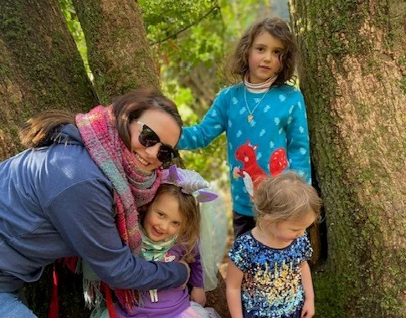 Deb Lewis and her three children stood by a tree