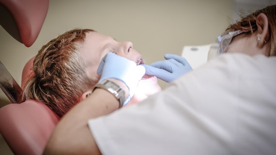 Child having teeth inspected by dentist
