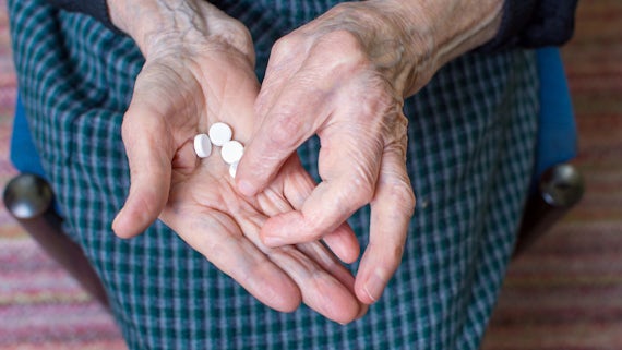 Elderly lady with pills in hand