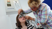 Image of Head of the clinic performing eye test on patient