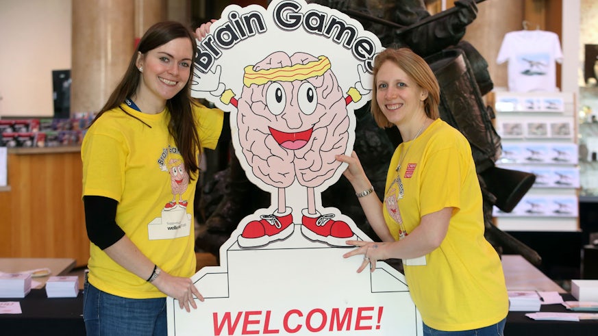 Brain Games volunteers hold welcome sign