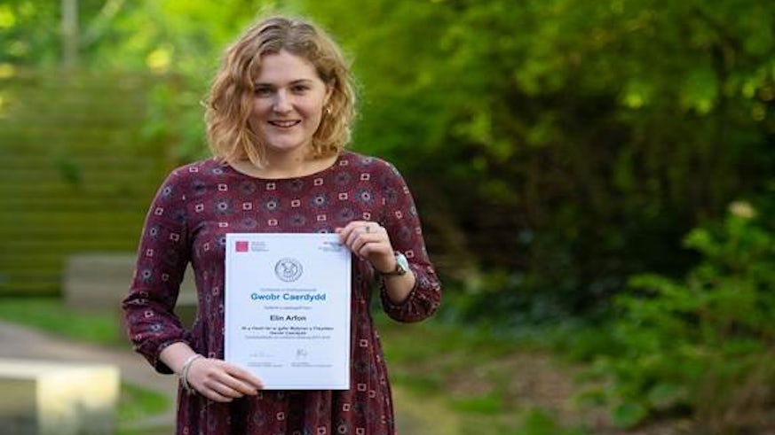 Female student holding a certificate