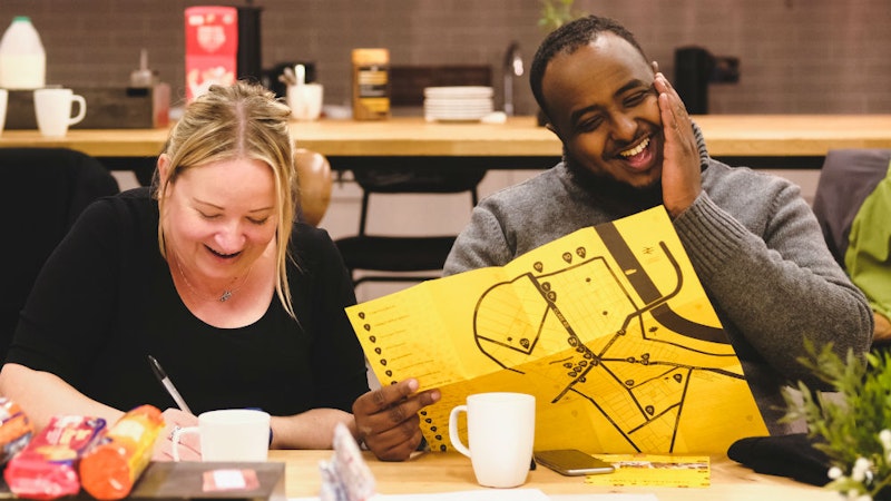 Two members of the Community Gateway project sitting at a table, laughing