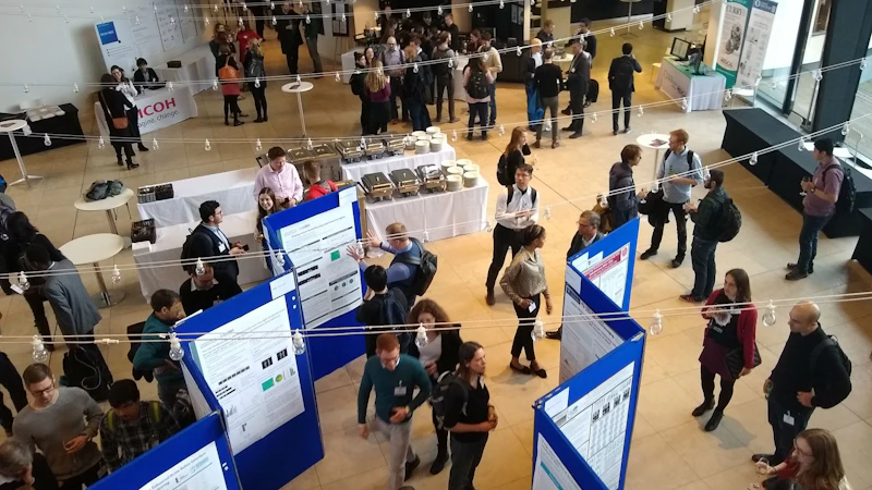 MEG researchers look at poster presentations in an atrium