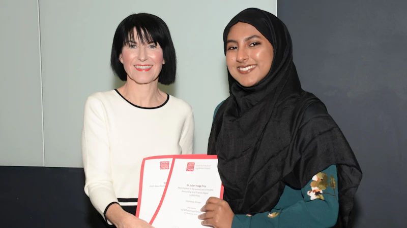 Female student collects two awards from Dean