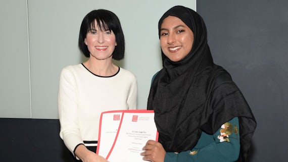 Female student collects two awards from Dean