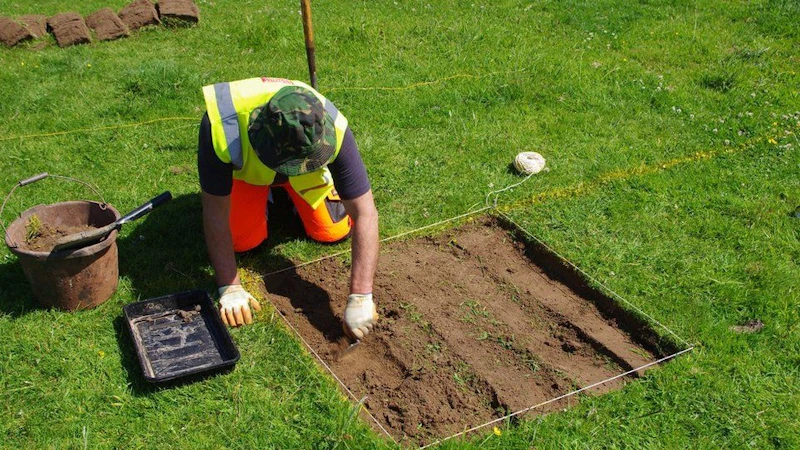 An archaeologist digging a trench.