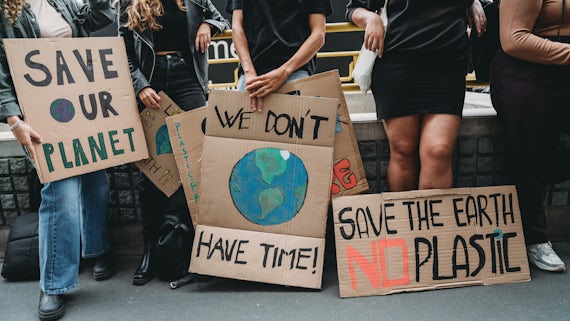 People are holding banner signs while they are going to a demonstration against climate change - stock photo