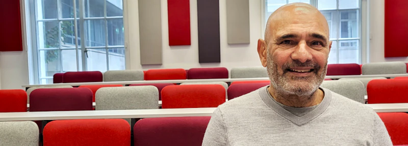 A man smiling in a lecture theatre