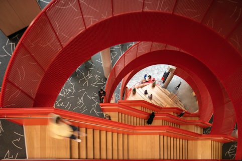 Photograph looking down the staircase in spark as people stand around or walk down the stairs