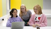 Three female students looking at a laptop