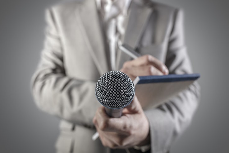 Man holding notepad and microphone