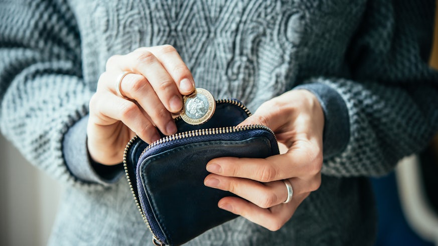 Hands holding a coin and a purse