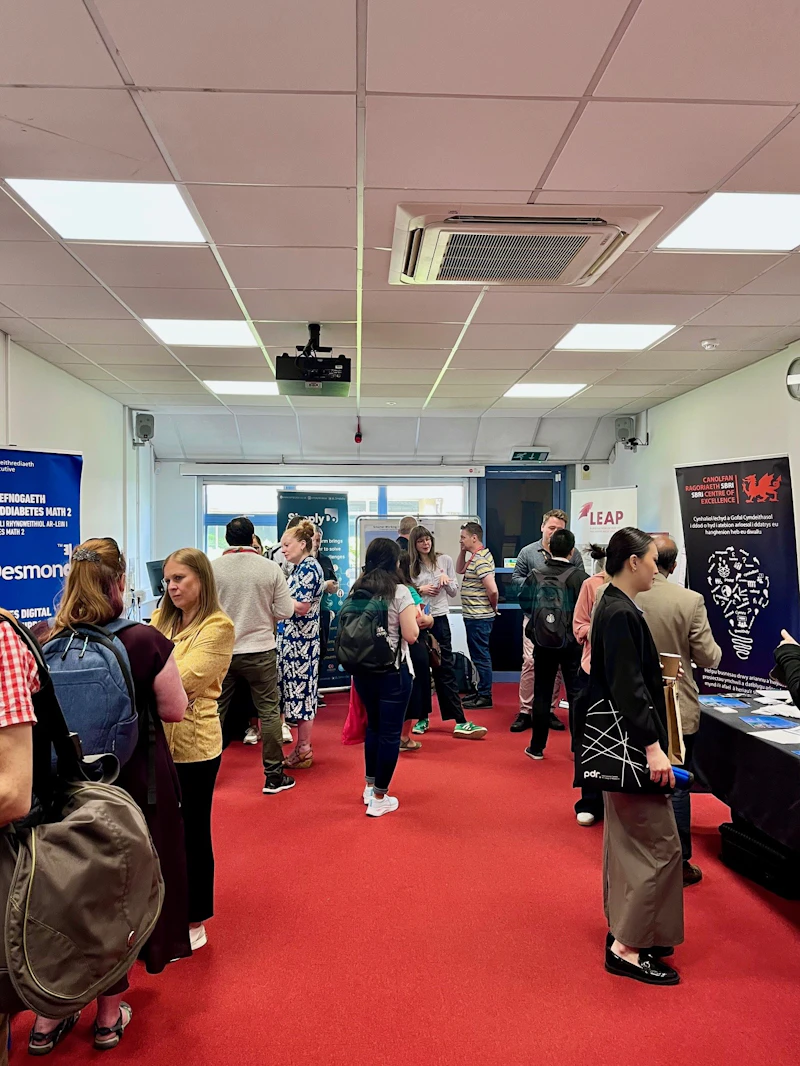 People talking and visiting business stands in a room set up in expo style