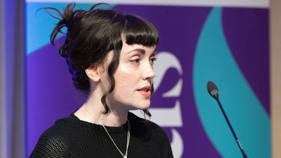A woman addressing an audience at a conference