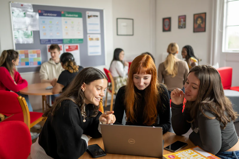 Students surrounding a laptop in class