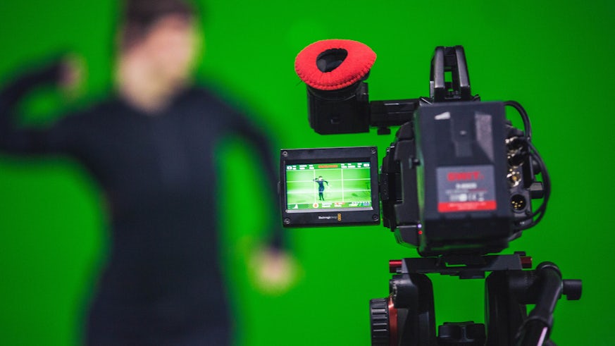 Stock image of TV camera filming person in front of a green screen