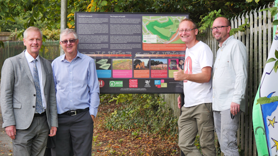 Staff and stakeholders around information sign