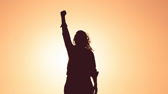 Silhouette of person with fist in the air