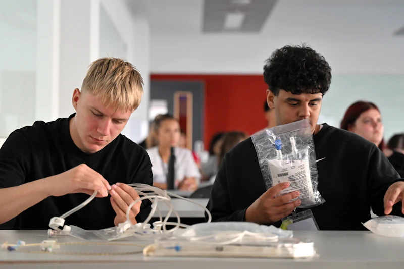 Students handling medical tubing equipment as part of a healthcare‑themed Step Up workshop.
