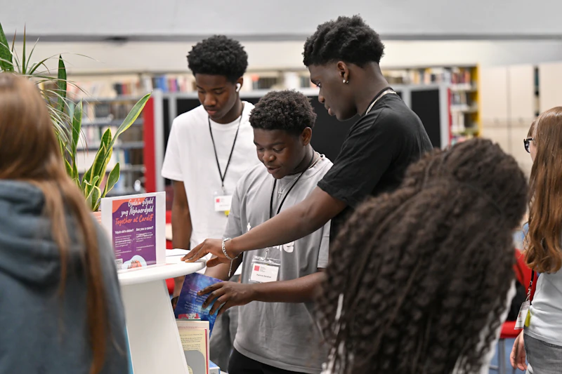 Students exploring resources and information during a Step Up activity in a library space.