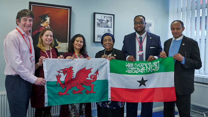 Edna Adan with Cardiff University staff holding the Welsh flag and the Somaliland flag