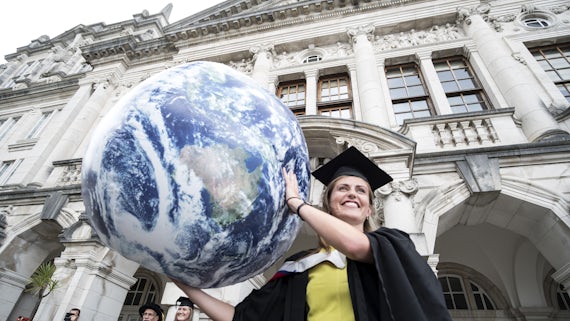 Earth and Ocean Science graduate with globe