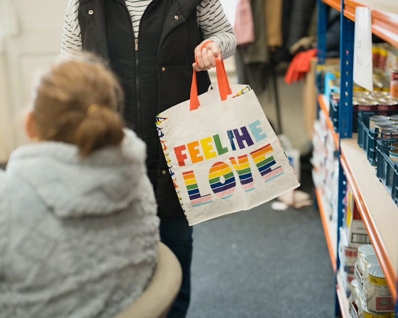 A person holding a multicoloured bag in a shop. 
