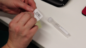 Photograph of a woman putting a barcode sticker on a test tube