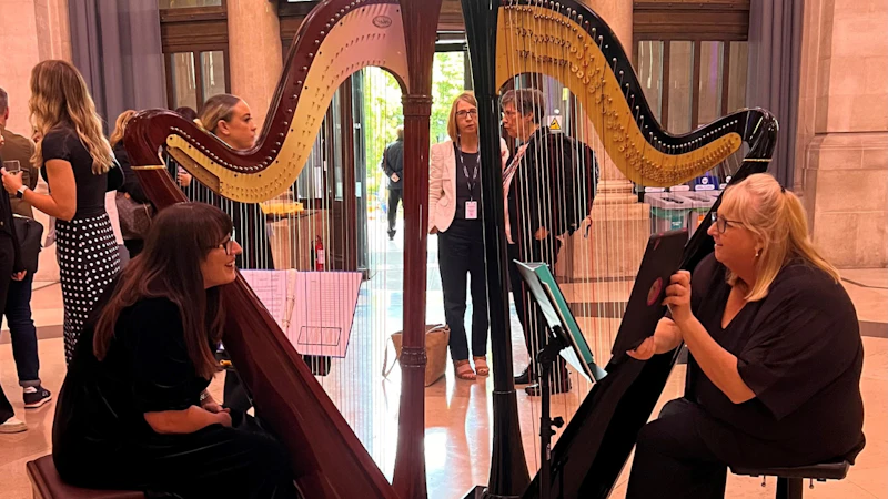 2 ladies playing a harp