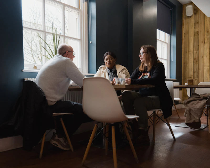 Three people sitting around a table 