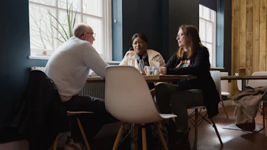 Three people sitting around a table